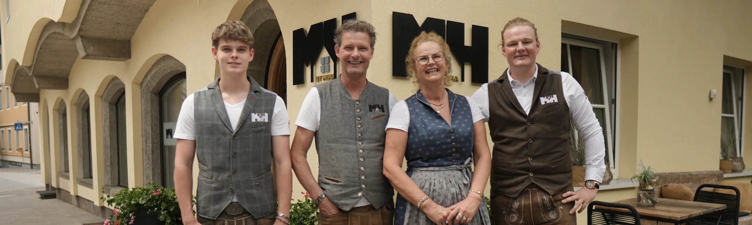 Familie vor einem Restaurant, alle in Westen gekleidet