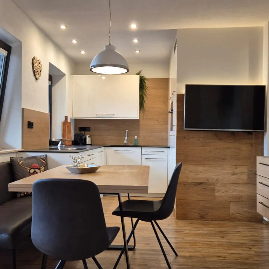 Modernes Esszimmer mit Tisch, Stühlen und Küchenbereich.