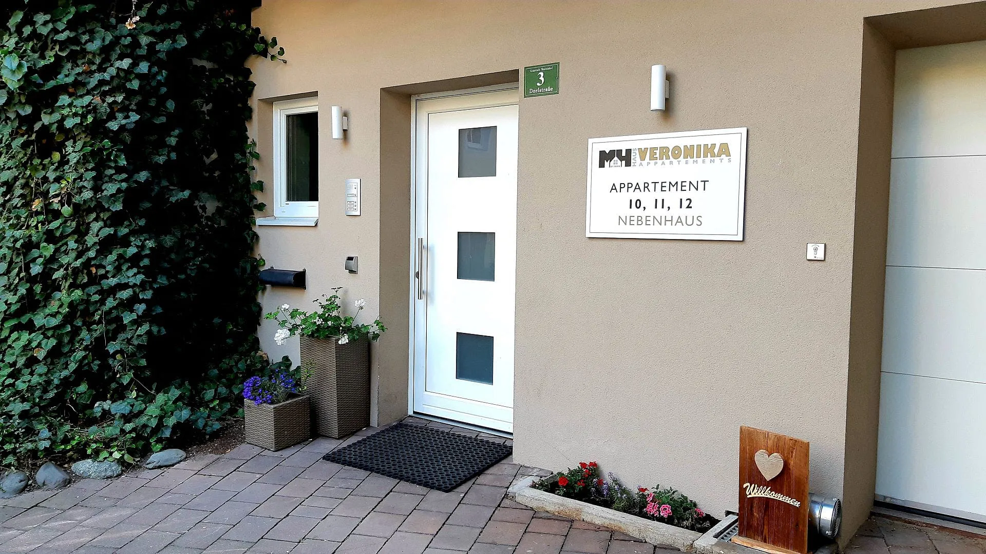 Eingang zum Appartementhaus mit Pflanzen an der Wand
