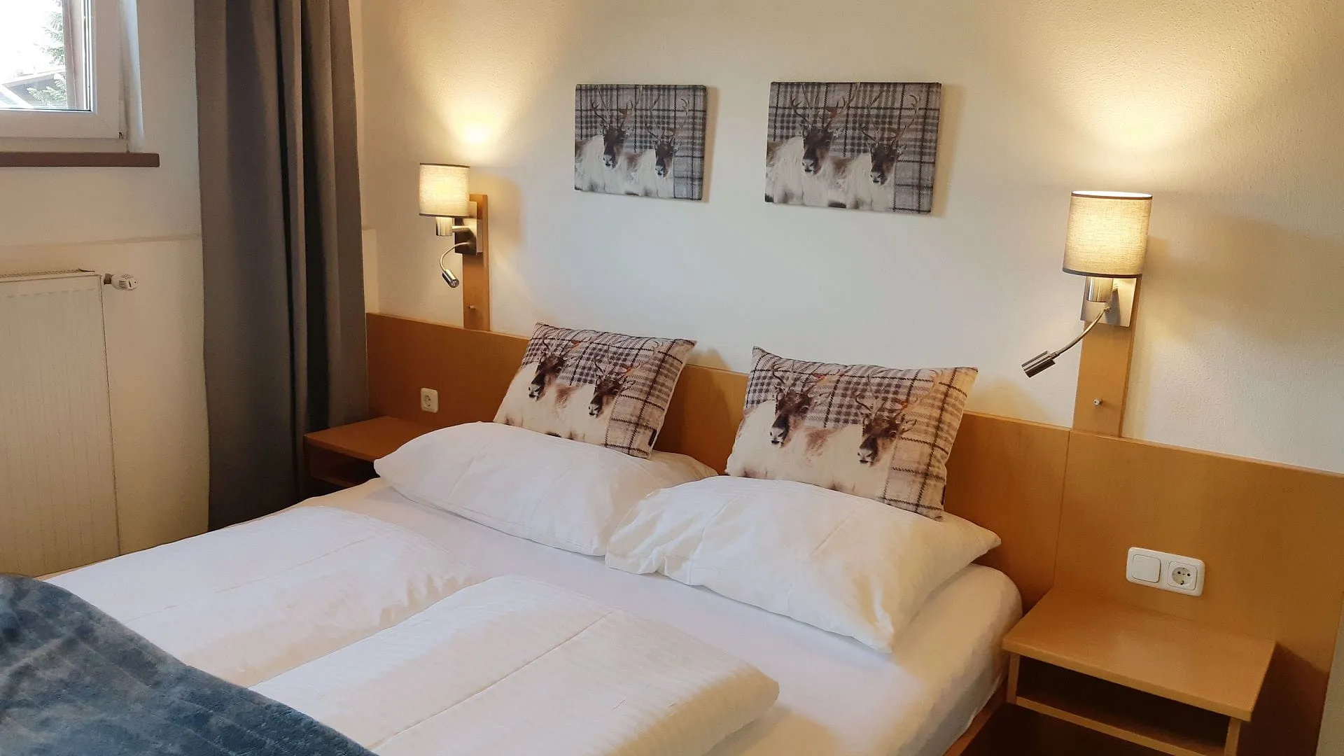 Helles Schlafzimmer mit Doppelbett und Kunstwerken an der Wand