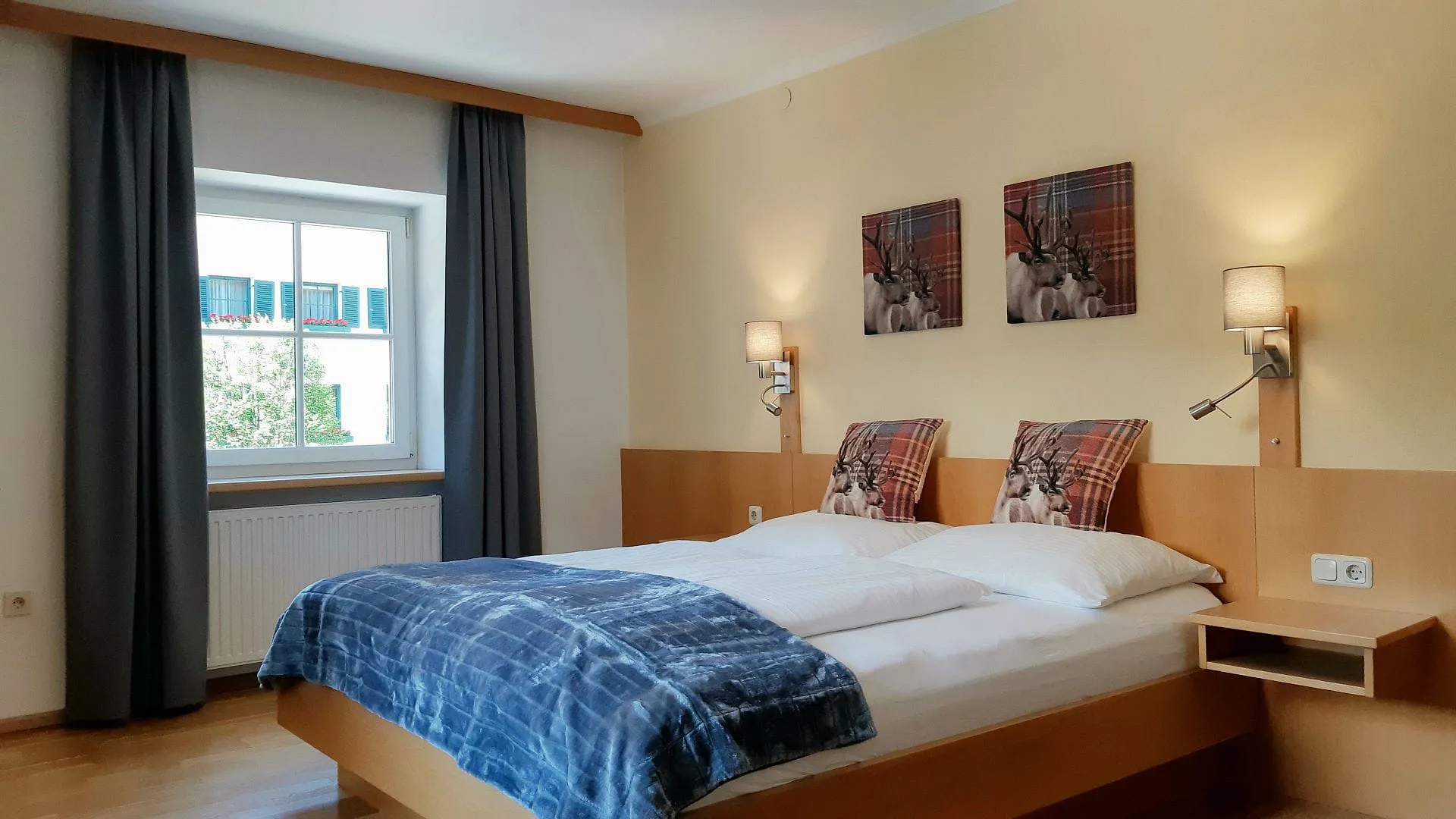 Helle Hotelzimmer mit Doppelbett und Fenster.