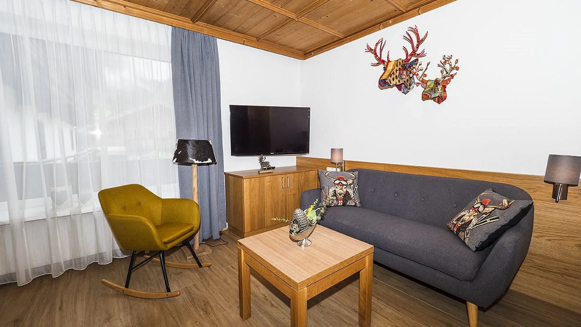Heller Wohnraum mit Sofa, Tisch und Fernseher.