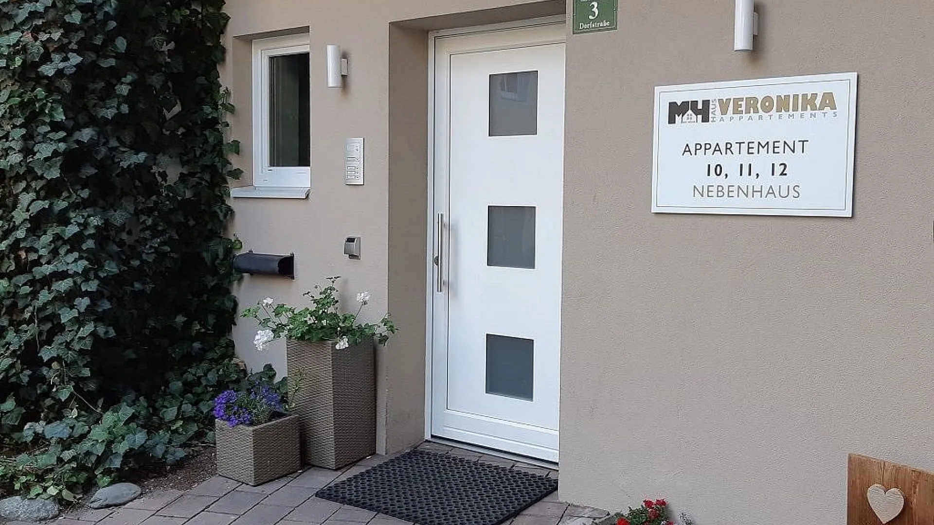 Eingang der Appartements Veronika mit Schild und Pflanzen