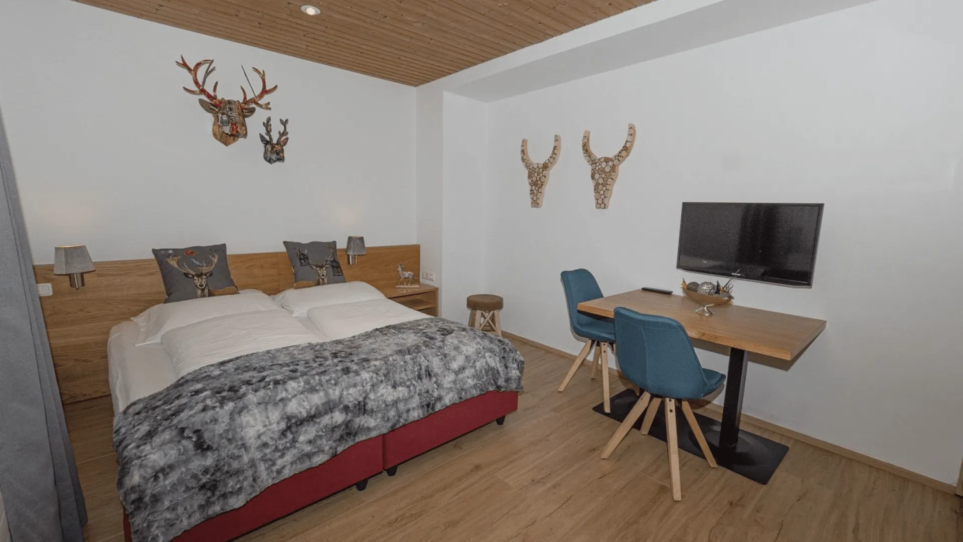 Heller Schlafzimmer mit Holzdecken und einem Schreibtisch