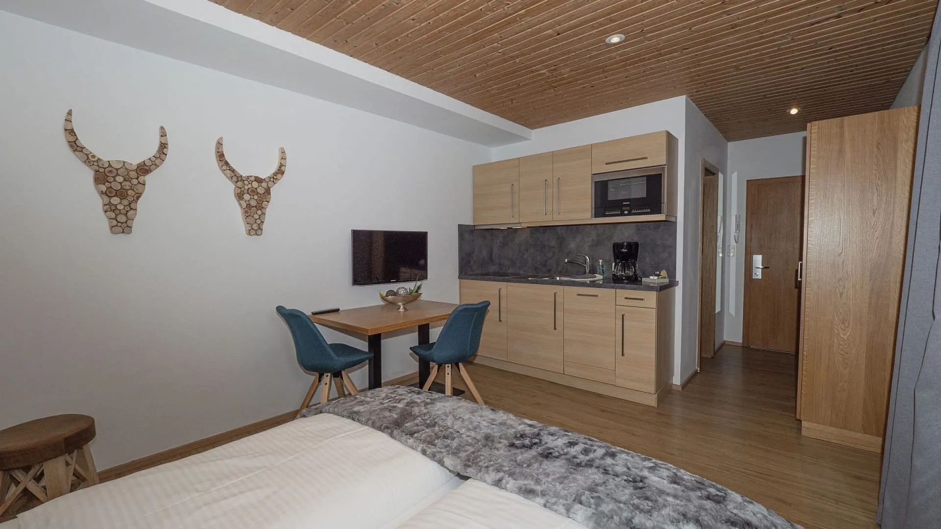 Holzdekoriertes Zimmer mit Tisch und Küchenzeile