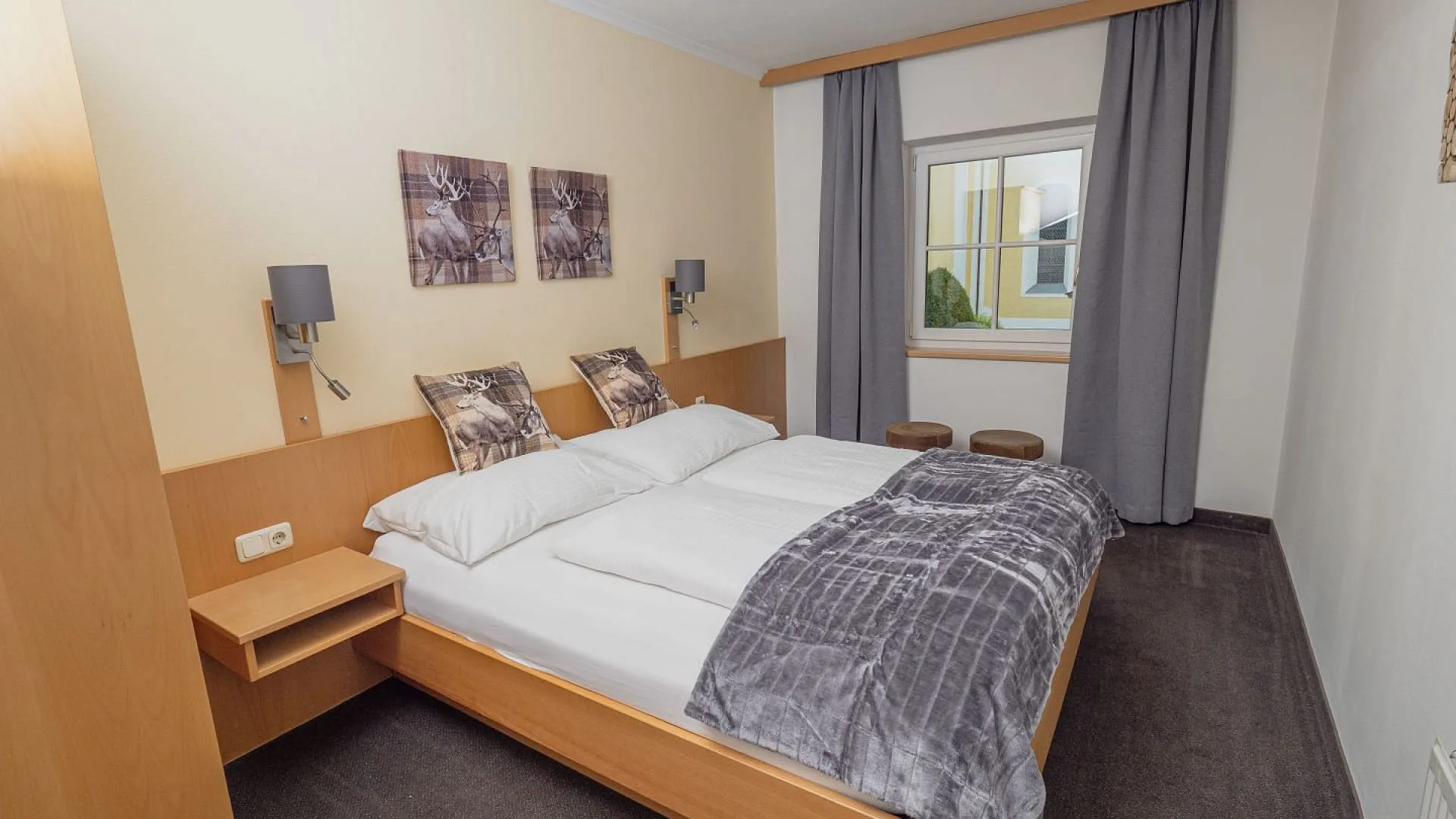 Helles Schlafzimmer mit Doppelbett und Fenster.