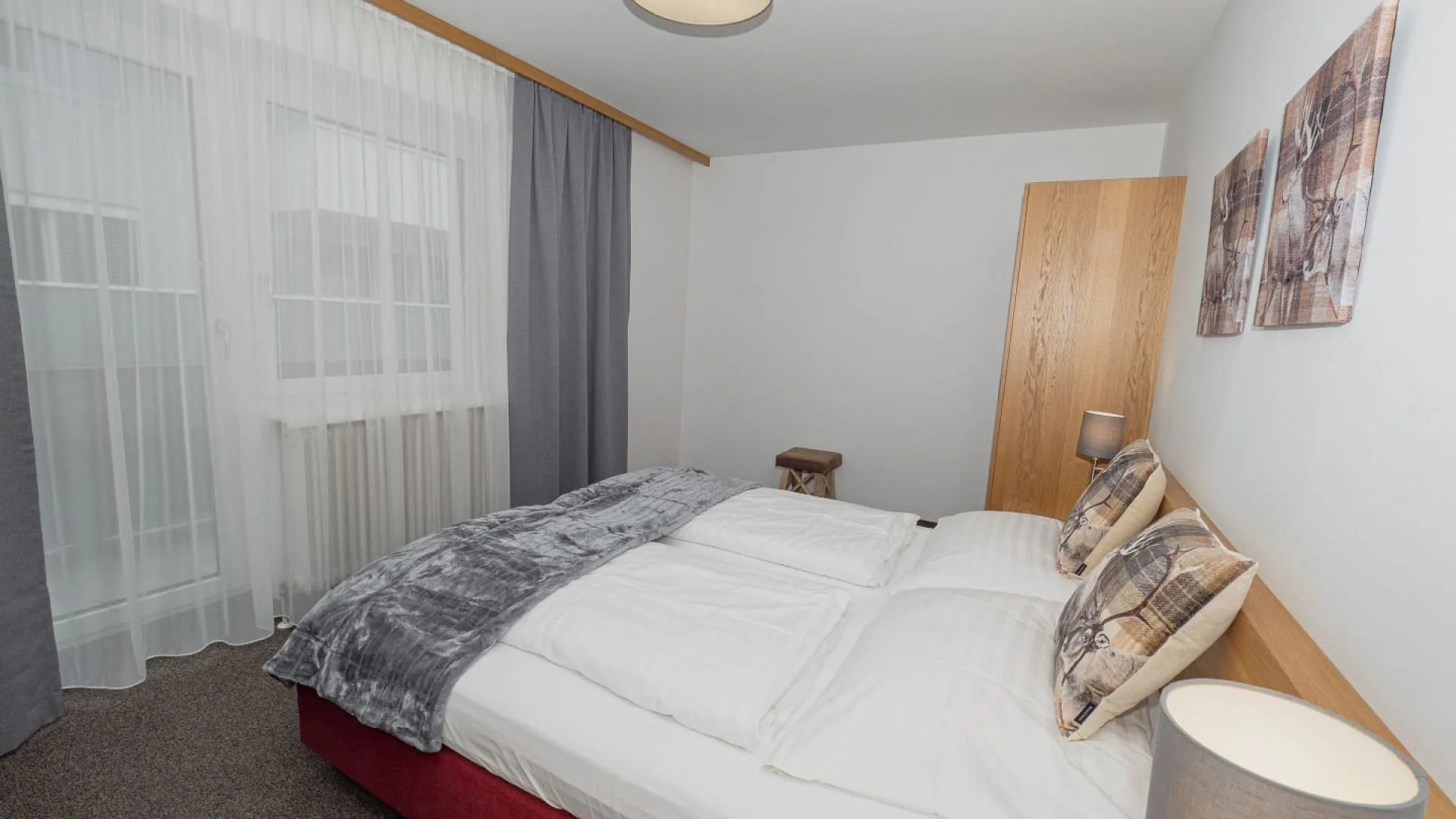 Helles Schlafzimmer mit Bett und Fenster in neutralen Farben