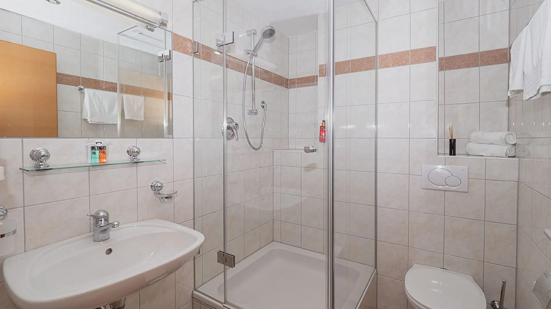 Badezimmer mit Dusche, Waschbecken und WC.