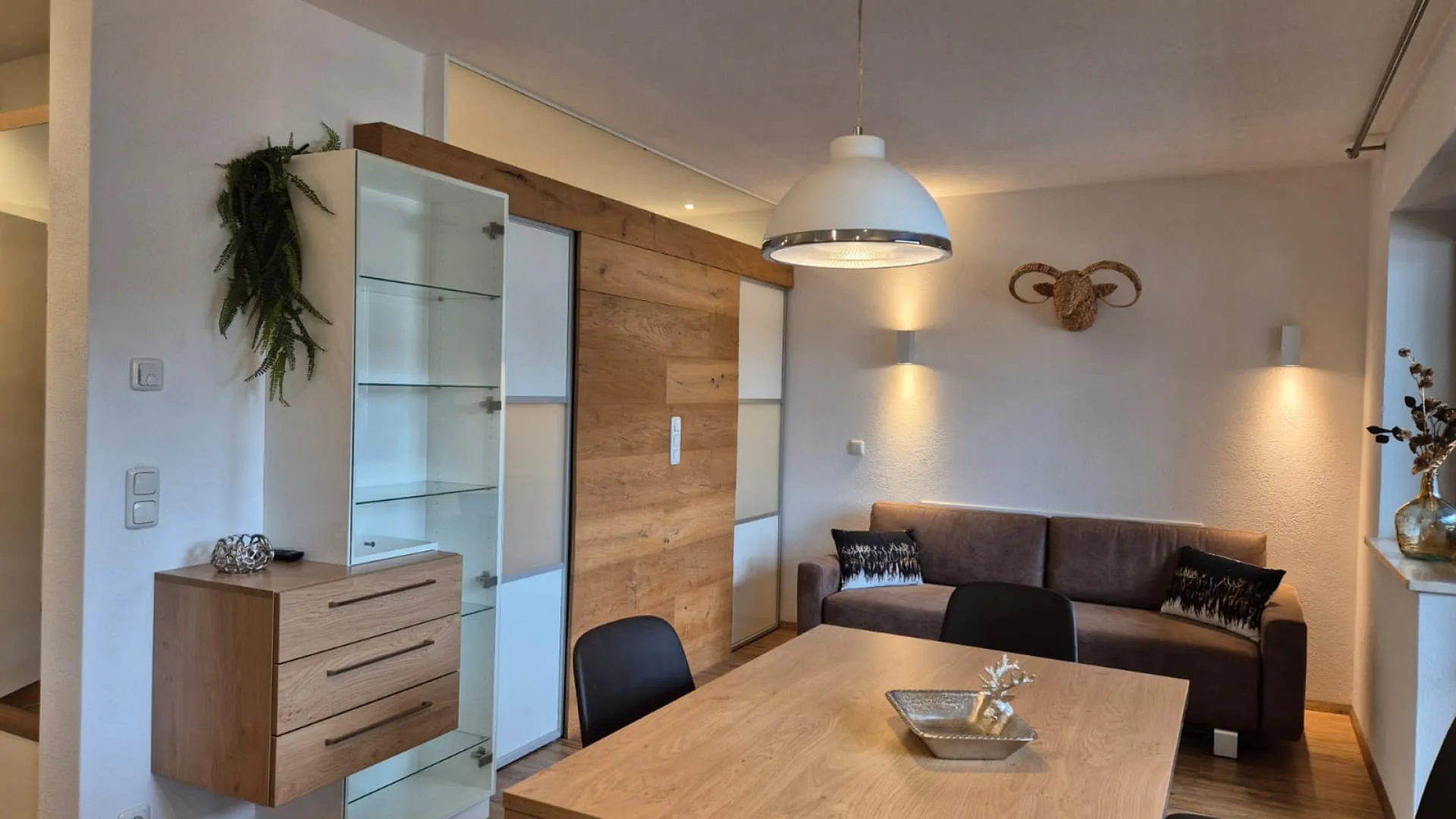 Helles Wohnzimmer mit Holzregal und Sofa
