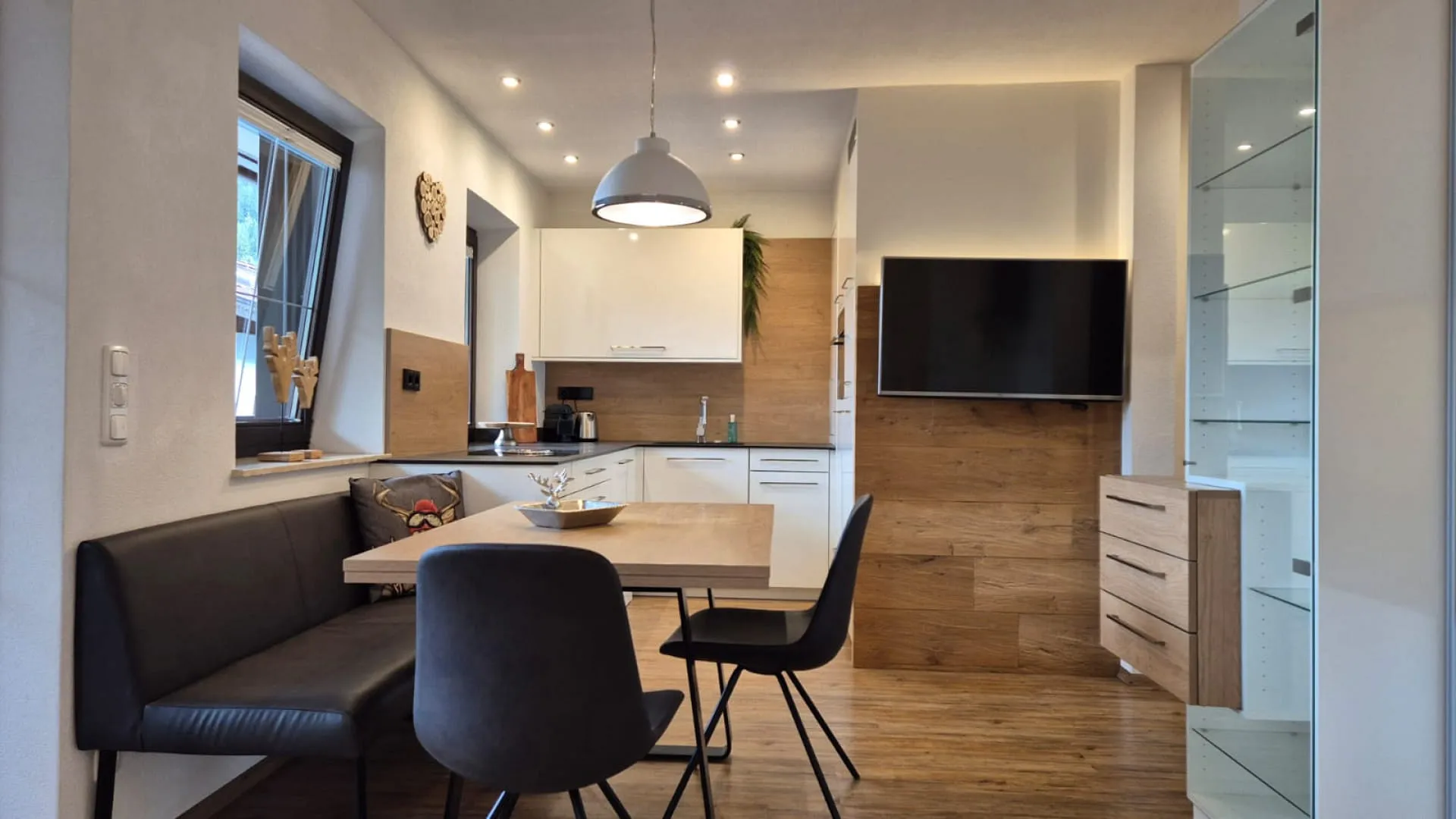 Modernes Esszimmer mit Holzdetails und TV.